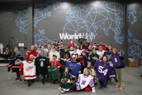Photo of volunteers in front of World Help wall 