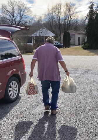 Loader carrying groceries to a client's car.
